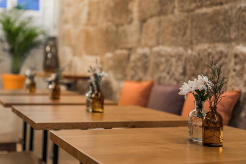 a row of wooden tables with vases with flowers in them at Porto River Infante in Porto