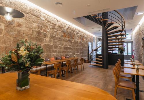 a restaurant with wooden tables and chairs and a brick wall at Porto River Infante in Porto