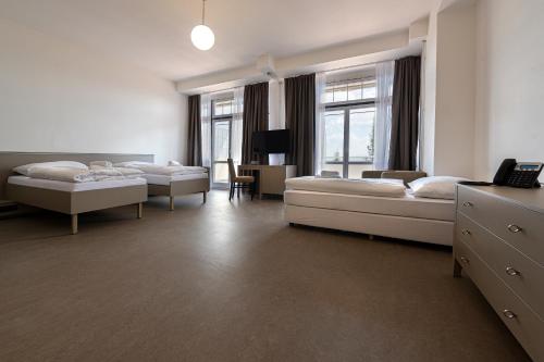 a hotel room with two beds and a desk at Hotel Granit Nová Polianka*** - klimatické kúpele in Vysoké Tatry