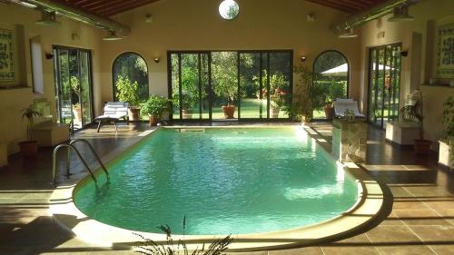 an indoor swimming pool in a house with a pool at Montebelli Agriturismo & Country Hotel in Caldana