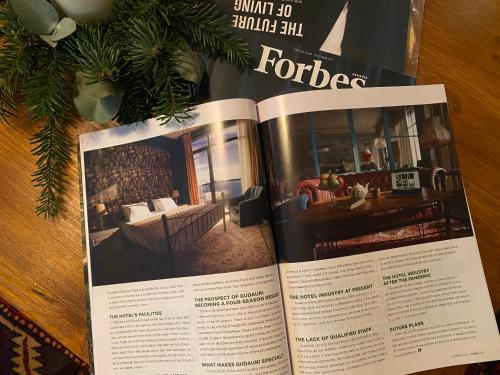 an open book on a table with a living room at Ati Ambavi Botique Hotel Gudauri in Gudauri