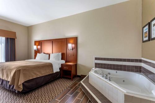 a hotel room with a bed and a bath tub at Comfort Inn & Suites Carbondale University Area in Carbondale