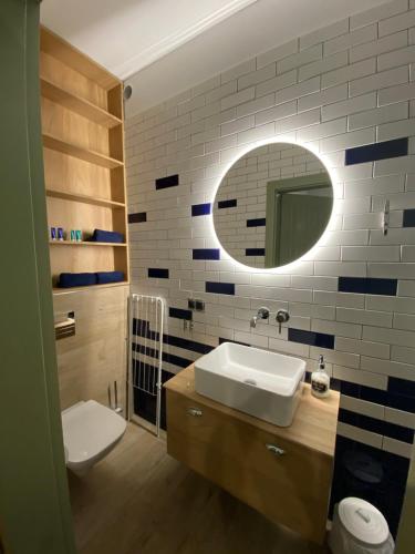 a bathroom with a sink and a mirror at Apartament Poezja Ciszy in Dębki