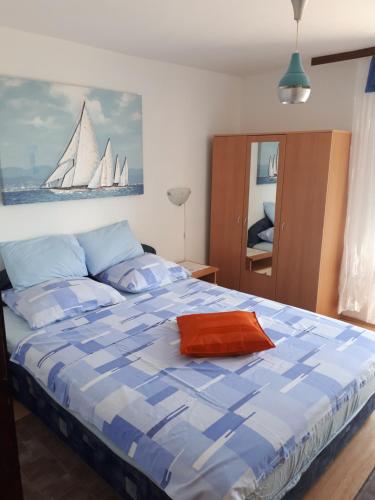 sypialnia z dużym łóżkiem z obrazem żaglówki na ścianie w obiekcie Apartments Kipson w Nin