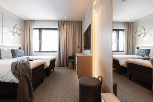 a hotel room with two beds and a mirror at Lapland Hotels Arena in Tampere