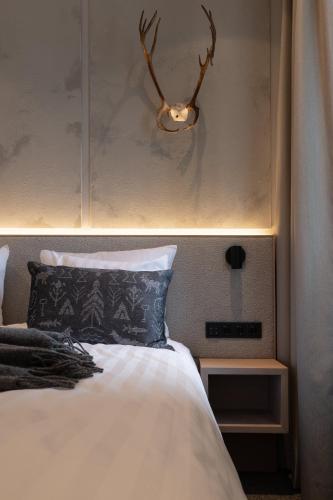 a bedroom with a bed with a antlers on the wall at Lapland Hotels Arena in Tampere
