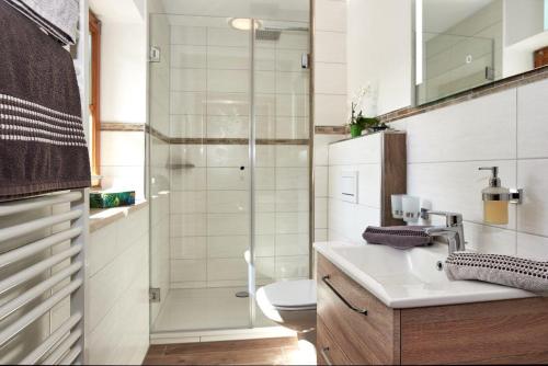 シェーナウ・アム・ケーニッヒスゼーにあるFerienwohnung Grünsteineckのシャワー、洗面台、トイレ付きのバスルーム