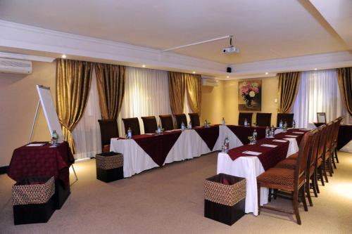 a banquet room with tables and chairs and curtains at Anta Boga Hotel in Bloemfontein