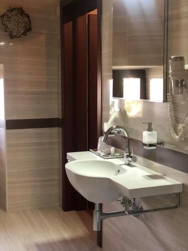 Un baño con un lavabo blanco y un espejo. en Residenza Ducale, en Bovino