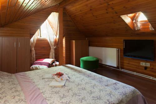a bedroom with a bed and a flat screen tv at Orhan Kutbayin Evi in Buyukada