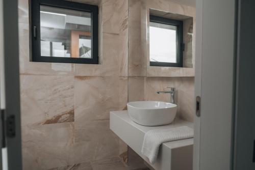 a bathroom with a white sink and a mirror at Cabo Villas in Arapya