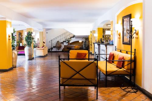 a lobby with yellow walls and yellow chairs at Le Dune Sicily Hotel in Catania