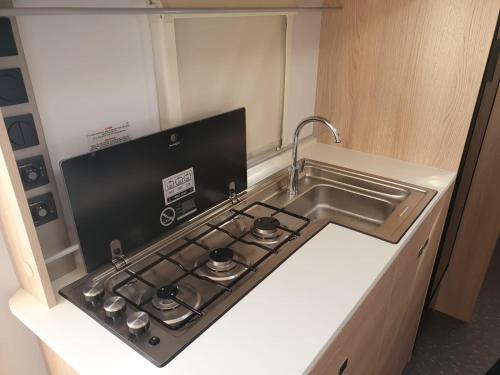 a kitchen with a stove top oven next to a sink at red sea beach caravan - קרוואן על חוף הים האדום in Eilat