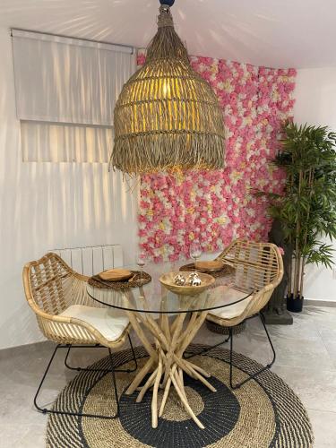 a dining room with a glass table and chairs at Studio cosy avec balnéothérapie in Saint-Étienne