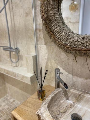 a bathroom with a sink and a mirror at Studio cosy avec balnéothérapie in Saint-Étienne