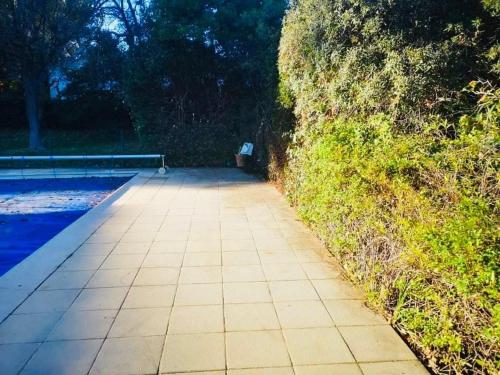 un trottoir carrelé à côté d'une haie avec banc dans l'établissement Villa La Verne, à La Seyne-sur-Mer
