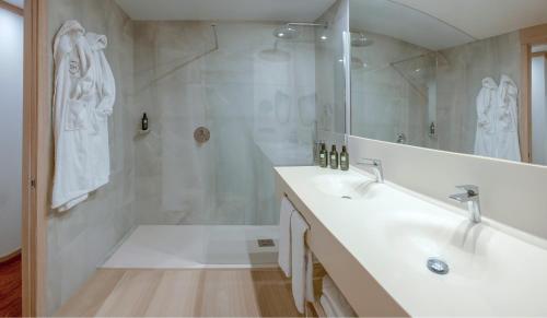 a white bathroom with a sink and a shower at SH Valencia Palace in Valencia