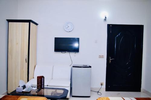 a living room with a chair and a tv and a door at Hotel Tulip Inn in Lahore