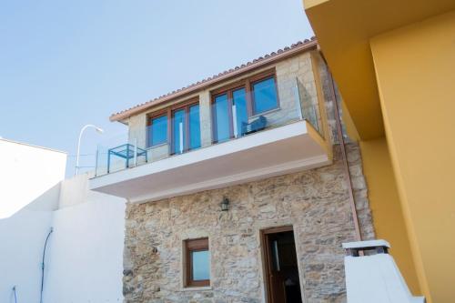 a building with a balcony on top of it at Casas Mar de Fisterra in Finisterre