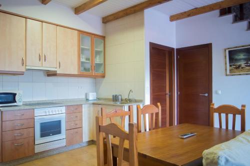 a kitchen with a wooden table and a dining room at Casas Mar de Fisterra in Finisterre