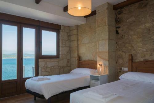 フィニステレにあるCasas Mar de Fisterraのベッドルーム1室(ベッド2台付)が備わり、海の景色を望めます。