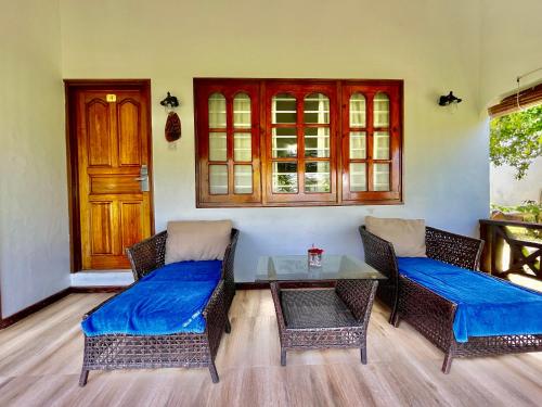 a living room with two wicker chairs and a table at Villa Chez Batista in Takamaka
