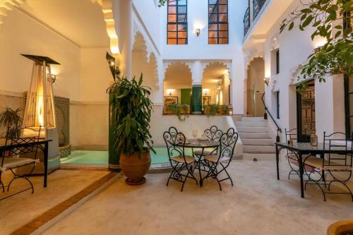 uma sala com mesas e cadeiras e um vaso de plantas em Riad Hart Essoura em Marrakech