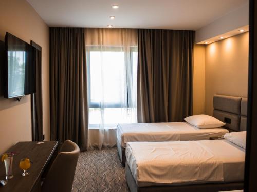 a hotel room with two beds and a window at Garni Hotel FILIA in Nova Pazova