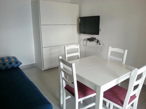 a white dining room table with two chairs and a tv at 230 MESTRO in Stanići