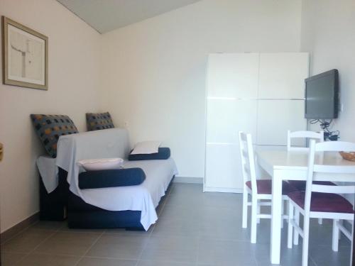 a room with a table and a bed and a table and chairs at 230 MESTRO in Stanići