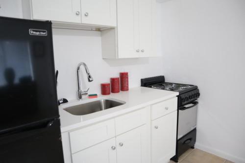a kitchen with a sink and a black refrigerator at Singer Island Inn/ Deluxe Studio in West Palm Beach