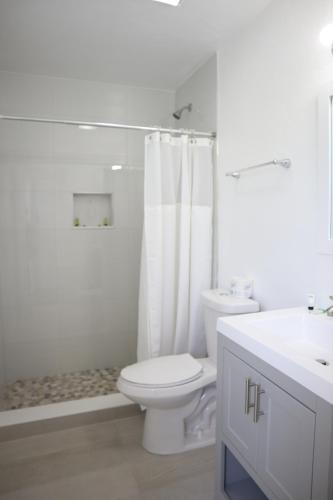 a white bathroom with a toilet and a sink at Singer Island Inn/ Deluxe Studio in West Palm Beach