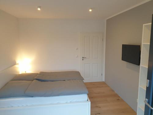 a bedroom with a bed and a flat screen tv at Willkommen zu Hause, ankommen & wohlfühlen ! in Tremsbüttel
