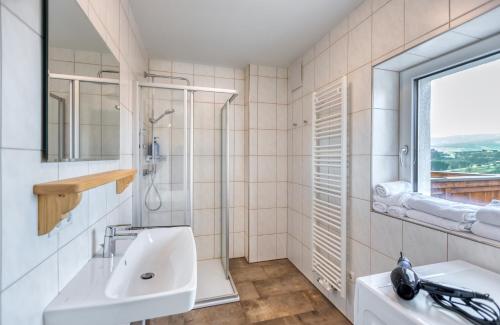 La salle de bains blanche est pourvue d'un lavabo et d'une fenêtre. dans l'établissement Apartment Lannach, à Lannach