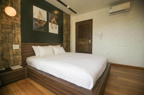 a bedroom with a large bed with white sheets at Fati Boutique Hotel & Apartment in Vung Tau