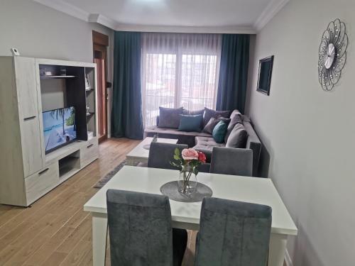 uma sala de estar com uma mesa e um sofá em Apartman DalMe em Novi Pazar
