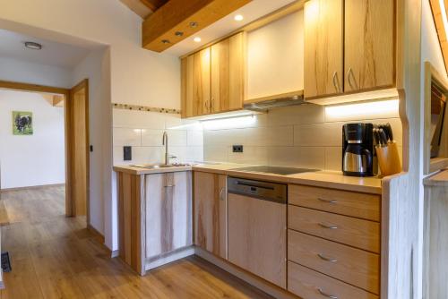 a kitchen with wooden cabinets and wooden floors at Der Anderlbauer am See in Schliersee
