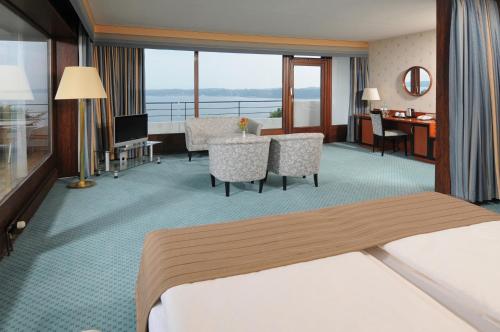 a hotel room with a bed and a living room at Maritim Hotel Bellevue Kiel in Kiel