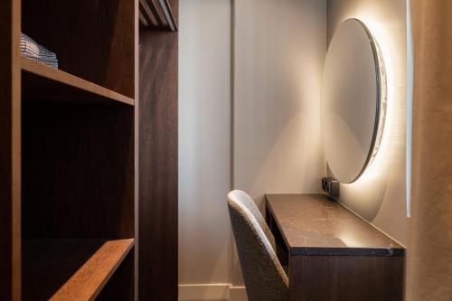 a dressing table with a mirror and a chair at Lapland Hotels Arena in Tampere