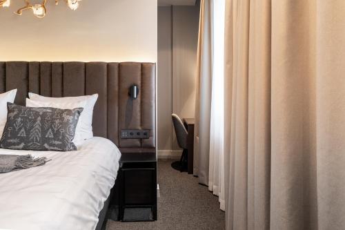 a bedroom with a large bed and a mirror at Lapland Hotels Arena in Tampere