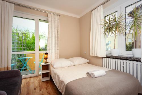 a bedroom with a bed and a large window at APARTAMENT 16 in Zamość