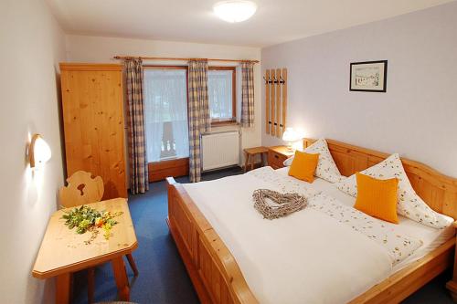 1 dormitorio con 1 cama grande y 1 mesa en Haus Hirschpoint Ferienwohnungen, en Ramsau