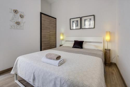 a bedroom with a white bed with two towels on it at Apartamento Planta Baja in Los Abrigos