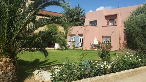 a house with a palm tree in front of a yard at Riad Dar Zidane in Meknès