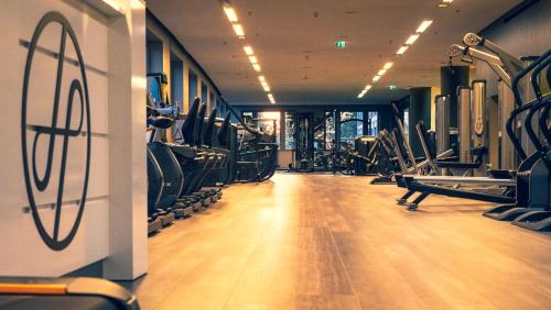 a gym with lots of cardio equipment on the walls at Dorint Hotel am Heumarkt Köln in Cologne