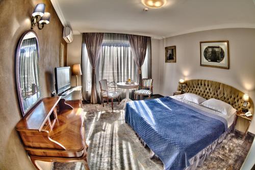 a hotel room with a bed and a desk at Meg-Lozenetz Hotel in Sofia