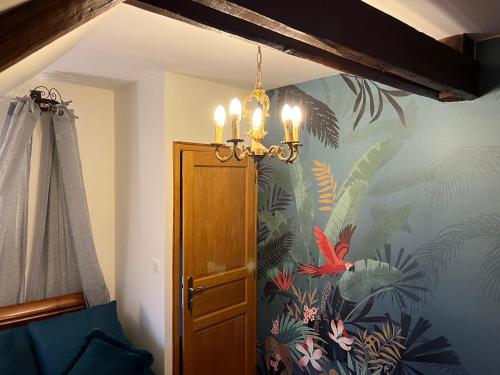 a chandelier in a room with a tropical wallpaper at Le Clos Saint Fiacre in Carentoir