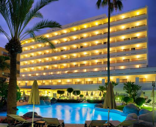 a hotel with a swimming pool in front of a building at Boutique Hotel H10 Big Sur - Adults Only in Los Cristianos
