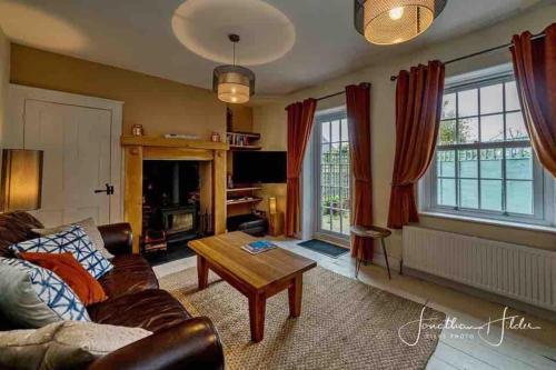 a living room with a couch and a table at Stay in our beautiful 1850’s Coastguards Cottage. in Felpham