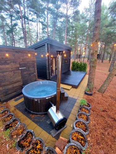 a large jacuzzi tub in a cabin in the woods at GaujaUpe in Gauja